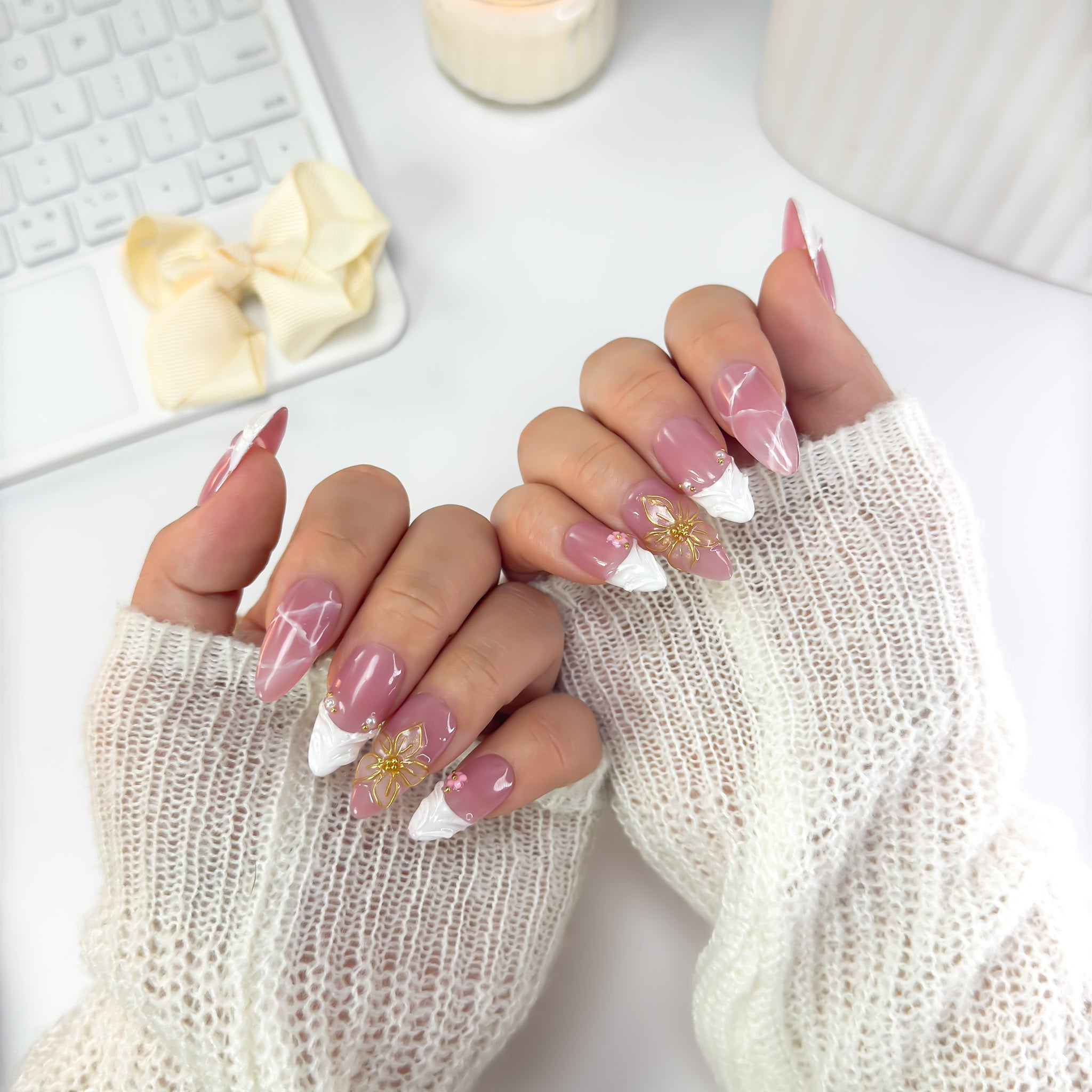 Blossoming press-on nails worn in a front-facing pose — radiant pink tones with gold floral designs and silver chrome details that capture feminine grace.