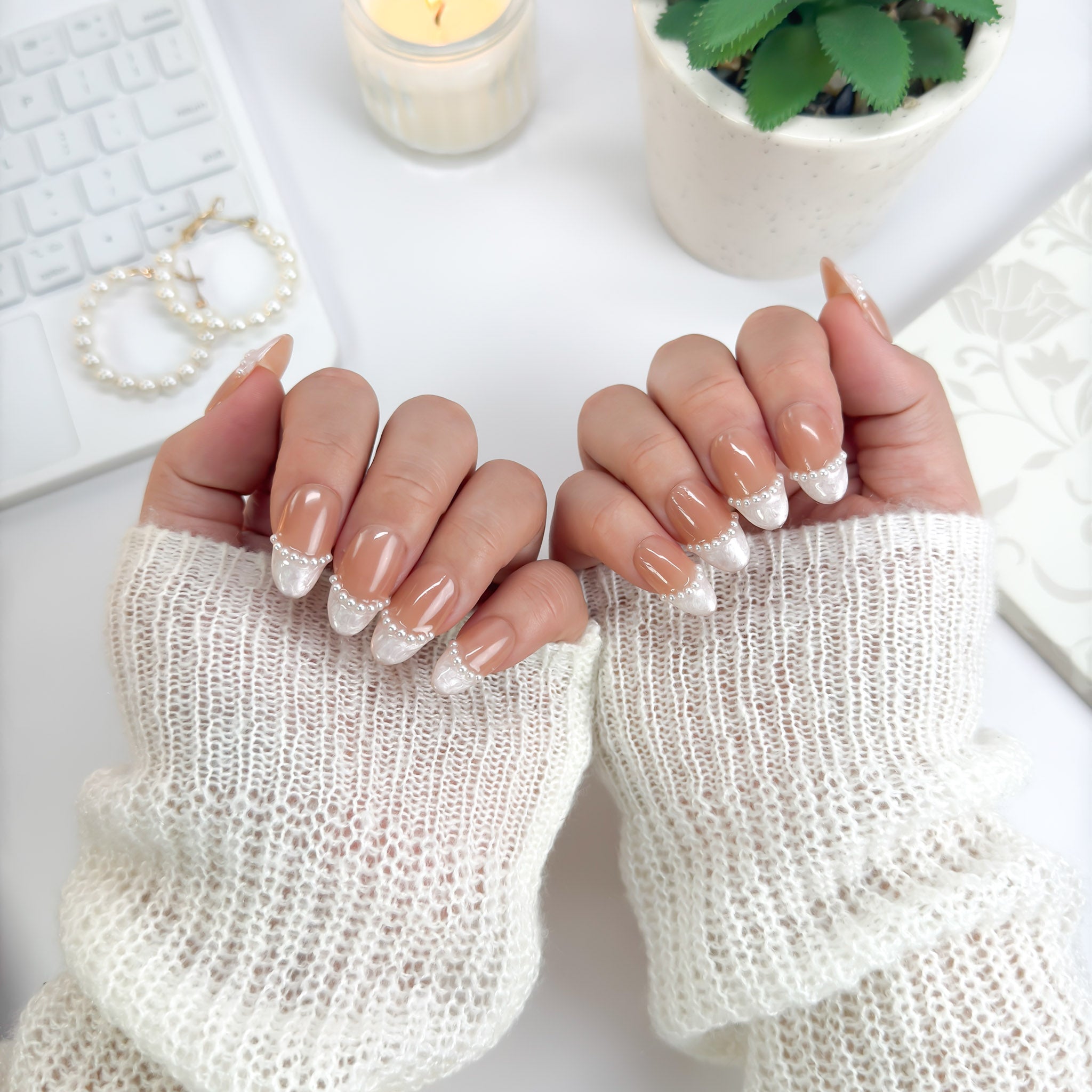 Top-down view of Pearl Veil nails — nude and pearl-toned press-ons with lace-like detailing and pearl accents for a refined, luminous look.