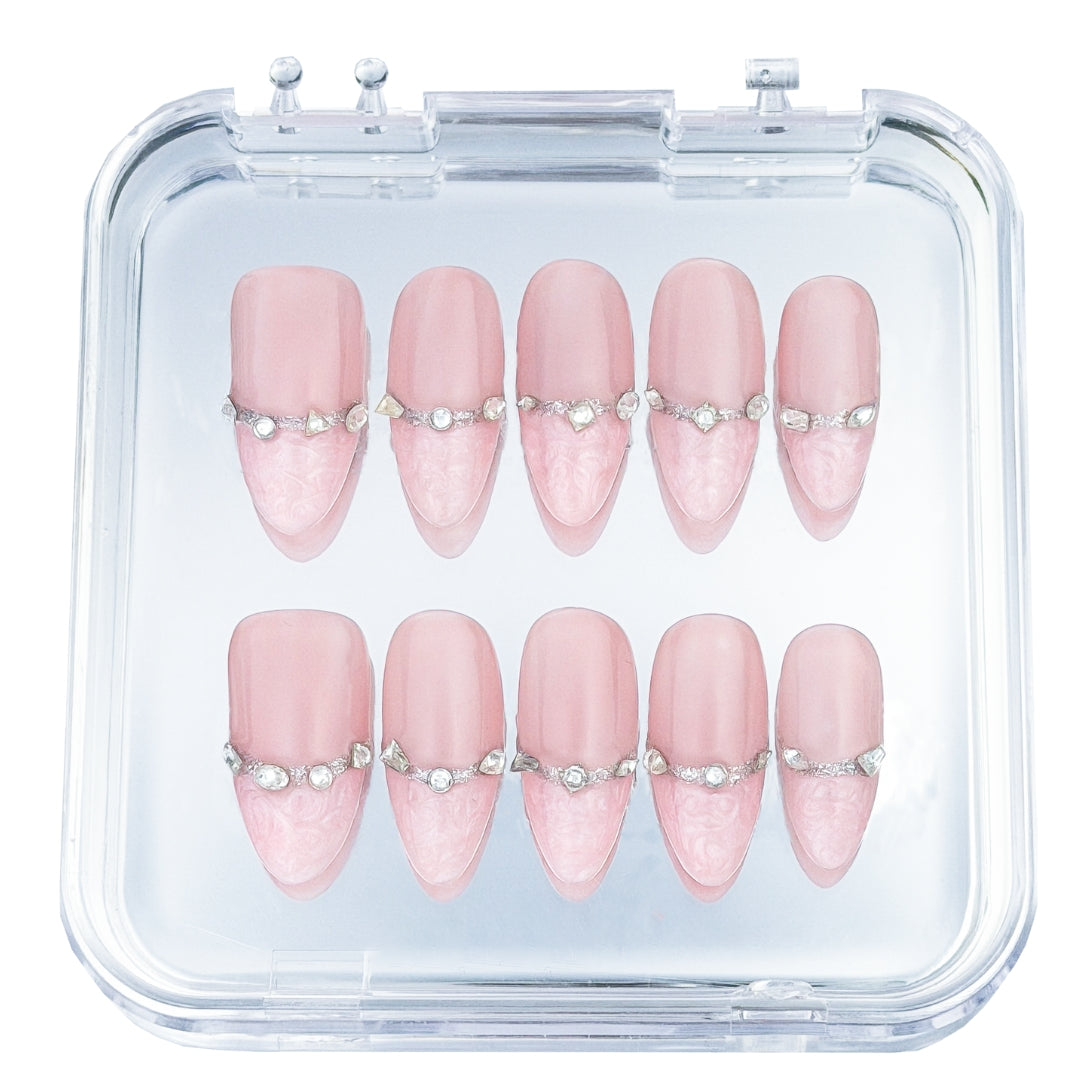 Rose Reverie press-on nails by Lunoxcore — delicate pink tones with crystal embellishments and lace-like tips, displayed elegantly in a clear case.