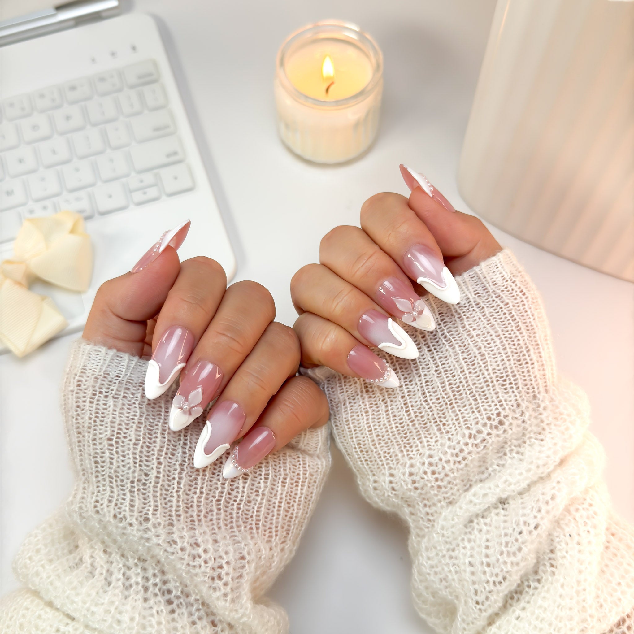 Soft Serve nails in a front-hand pose — a dreamy blush-and-white combo with smooth sculpted details and an elegant, feminine finish.