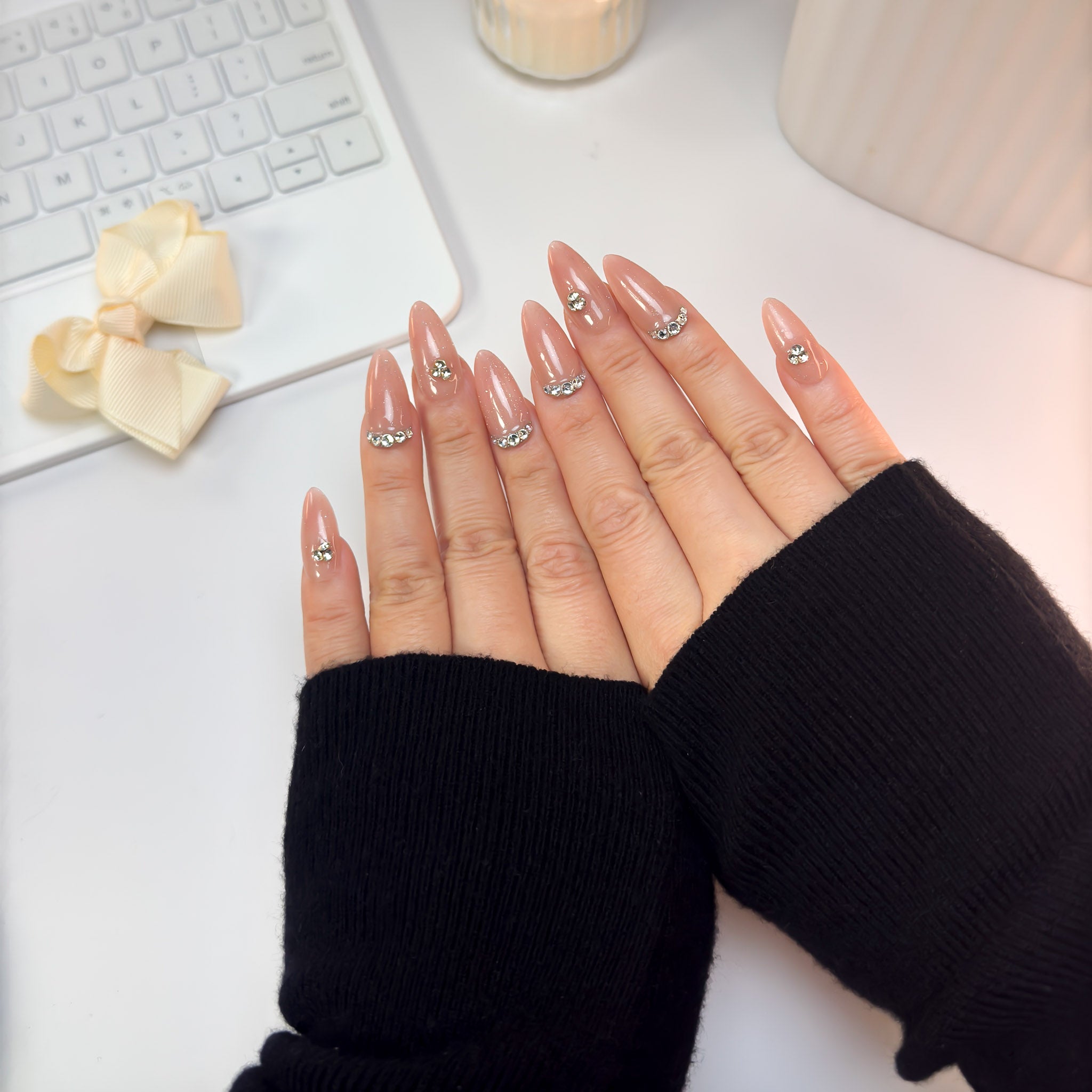 Twinkle Touch nails photographed from an angled view — capturing the soft shimmer, gentle blush hue, and radiant crystal details.