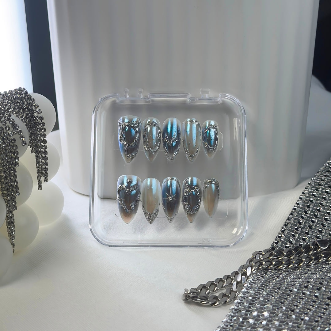 Lunoxcore Voltage press-on nails — vibrant blue and silver lightning-inspired design with futuristic metallic detailing from the Loudcore Glowbox collection.