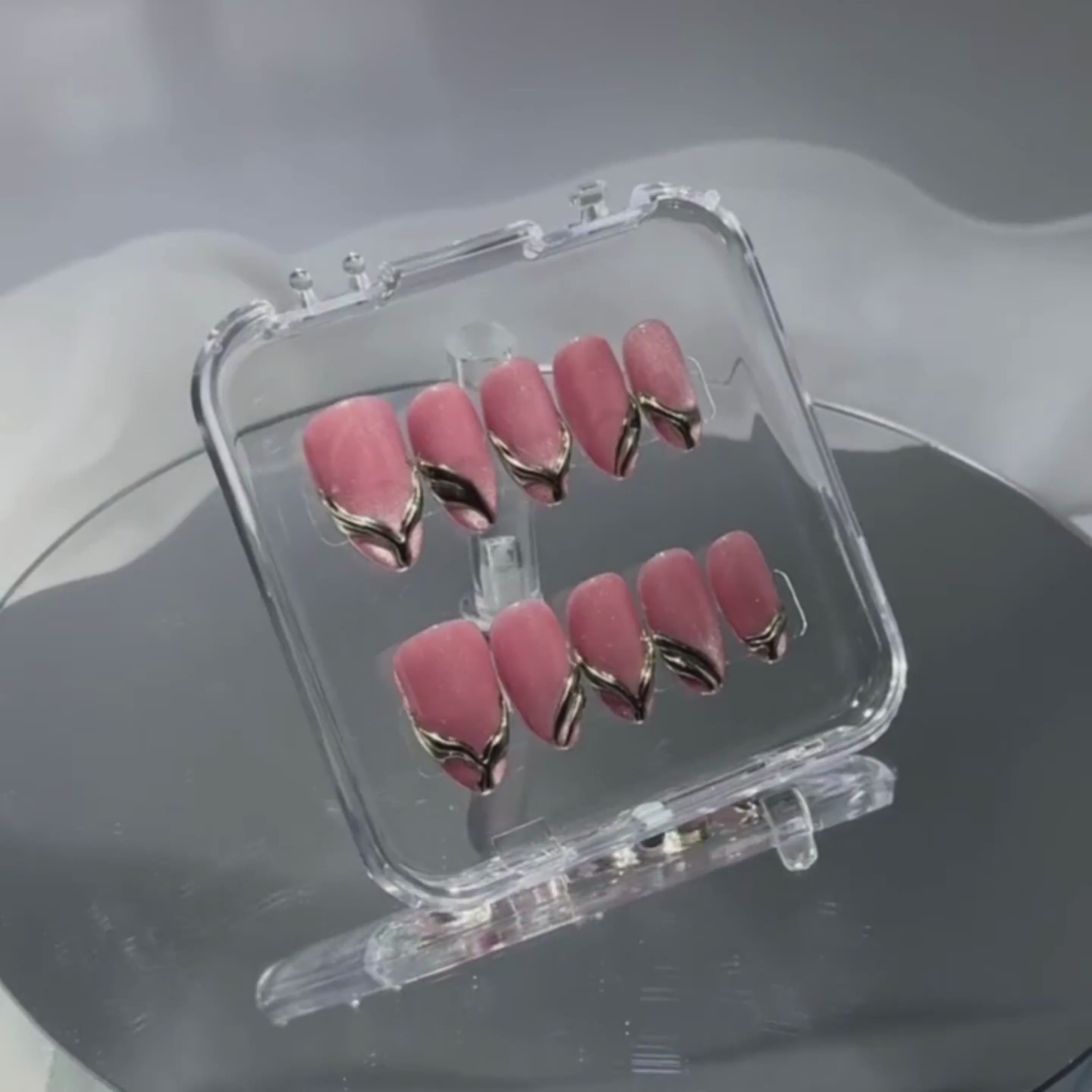 Video showcase of Gilded Strike — deep rose and gold press-on nails with a molten metallic finish that captures the light beautifully.